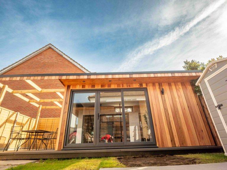 Cedar garden gym and office with sliding doors beside a covered decking area