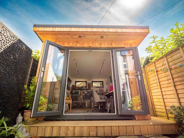 Cedar garden office with open double doors showing a desk and chair inside